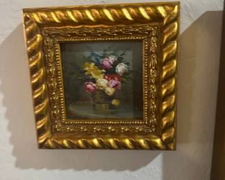 Small Gold Framed Floral Still Life — This small floral still life painting features a bouquet of colorful flowers arranged in a basket, presented in an ornate gold frame with a rope-twist design. The piece measures approximately 7.75 inches tall by 9.5 inches wide, making it a charming accent for any wall display. The gold frame has a richly detailed finish that enhances the classic floral artwork inside. The painting and frame are in good condition with minor surface wear consistent with age. This decorative piece offers a vintage look suitable for traditional home decor.