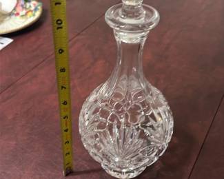 Vintage Crystal Decanter Clear — Clear vintage crystal decanter with faceted stopper and cut-glass body showcasing classic diamond and vertical cut patterns. The seller notes this is vintage crystal; the piece is clear glass/crystal with a fitted faceted stopper and substantial weighted base. Overall height is about 10 inches as shown in the photo with a sturdy square footprint ideal for bar or display use. In good condition with no visible chips or cracks in the photos, typical light surface wear from use may be present.