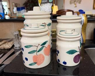 Hartstone USA Vintage Canister Set — This vintage Hartstone USA canister set features charming hand-painted fruit designs on a cream background, adding a warm, rustic touch to any kitchen. The set includes four ceramic canisters with lids, showcasing medium size and high-quality stoneware construction. The tallest canister measures approximately 9.5 inches in height, with others ranging down to about 5.5 inches, all with sturdy lids and a chip noted on a medium canister lid. These pieces are in good condition with minor wear typical for vintage kitchenware but retain vibrant colors and functionality. Perfect for collectors or those seeking attractive vintage kitchen storage from a respected American maker.