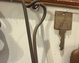 Iron Fireplace Shovel Longhorn — Hand-forged iron fireplace shovel with a pierced longhorn cattle head motif on the shovel blade and a twisted scroll handle. Sturdy utilitarian piece with a rustic brown/aged patina consistent with use and age; the blade shows surface wear and minor scratches but no breaks. Heavy gauge iron construction and simple rivet assembly make it a durable hearth tool or decorative accent for mantel display. Overall length is suitable for tending a residential fireplace and pairs well with other rustic hearth tools.