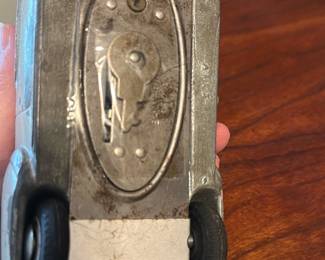 Pressed Steel Toy Car - Metal Coupe — Heavy pressed-steel toy car coupe with metal body and painted roof, likely a mid-20th-century diecast-style toy. The piece shows surface wear, paint chipping, and light surface rust on the underside and wheel wells; wheels appear original rubber or hard rubber tires. Measures approximately 3.5 inches long, 1.4 inches tall and 1.4 inches wide and is a compact collectible suitable for display on a shelf or in a toy car collection. Condition is fair with cosmetic wear and patina consistent with age; no obvious broken parts but paint and finish show age-related deterioration. Great for collectors of vintage pressed-steel toys or as a restoration project.