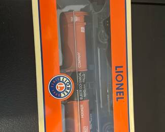 Lionel Hooker Chemical Tank Car — Lionel Hooker Chemical Tank Car in original orange/cream window box. Box text and label read "HOOKER CHEMICAL TANK CAR" and model number 6-26194; packaging notes die-cast metal sprung trucks with metal platform, rails and ladders. Clear display packaging shows the orange tank car with readable Hooker Chemical markings; item appears unused in box with light shelf wear to carton edges. Good collectible condition for Lionel O gauge train displays or layouts.