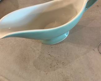 Shenango China Gravy Boat — Shenango China gravy boat marked "Shenango China New Castle, Pa." on the base. Pale aqua exterior with white glazed interior, classic mid-century diner/restaurant china form with integrated handle and footed base. Small surface wear and light rim roughness visible on the base but no large chips or cracks seen in photos. A useful serving piece for tabletop use or display; compact size fits standard serving needs.