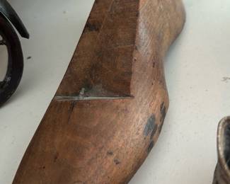 Wooden Cobbler Shoe Last — Antique wooden cobbler's shoe last in solid carved wood, a utilitarian tool used for shaping and repairing footwear. The last shows honest wear with surface marks, scuffs and a small chip at the toe consistent with long use; a metal loop/peg is present at the heel for hanging or securing. Sturdy, decorative and useful for shoemaking displays, craft projects, or vintage tool collections. Measures compactly and is lightweight for easy handling.