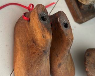 Wooden Shoe Lasts Pair — A pair of vintage wooden shoe lasts presented as a matched left and right form for shoemaking or display. Solid carved wood shows surface wear, small chips and patina consistent with age and use; metal nails or fittings remain in the heel area. Good rustic condition for decorative or craft use — useful as display pieces, pattern making props, or vintage decor. Each last measures roughly shoe-sized and is lighter than solid hardwood blocks.