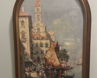 Arched Venetian Canal Print Framed — Framed arched wall print depicting a Venetian canal scene with gondolas, a sail bearing a cross motif, and waterfront buildings. Housed in a gold-tone ornate arched frame with applied floral ornament at the top; glazing appears intact though there is glare in photos. Good decorative condition with light surface wear to frame consistent with age; ready to hang and suitable for living room or hallway display. Measurements listed approximate the overall framed piece.