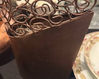 metal scrollwork tabletop planter — Decorative metal tabletop planter with open scrollwork upper and solid rectangular base. The piece is finished in a brown/bronze tone with visible surface wear and light scratches consistent with prior use; base holds dried decorative filler. Sturdy welded construction and compact footprint make it suitable for holding small potted plants or as a decorative faux arrangement container. No maker's marks or labels visible in photos; condition is fair with cosmetic wear only.