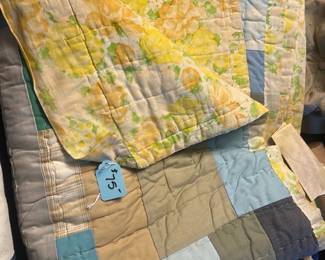 Patchwork Floral Quilt Set — Handmade patchwork quilt with a yellow floral reverse and muted blue/beige patch front shown folded. Quilting appears machine-stitched with visible wear consistent with used linens and some light soiling and creasing; overall intact with no major tears visible in photos. Sold as a single blanket/coverlet suitable for a guest room or layered bedding; lightweight vintage-style construction. Measures approximately as shown folded; buyer should inspect for spots or repairs before laundering.