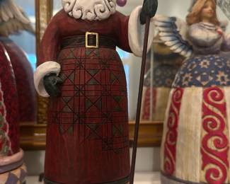 Jim Shore Santa Figurine — Jim Shore Santa carved-style figurine featuring a red robe with geometric and floral accents, white beard and staff. Marked on the base "Jim Shore" and carries an original $40.00 sticker; typical of Jim Shore's heartwood folk-art styling and painted resin construction. Good display condition with no visible chips or cracks in photos; finish shows light surface wear consistent with normal display. Stands approximately 9 inches tall (see dimensions) and is a decorative tabletop piece.