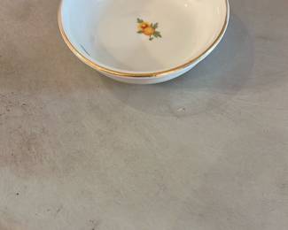 A.B. ÅKE BLOMQUIST Stockholm Bowl — Small porcelain bowl marked A.B. Åke Blomquist Stockholm with delicate painted floral motifs and a hand-applied gilt rim. The maker's backstamp is clear on the base and the bowl shows light surface wear consistent with gentle use; no chips or cracks visible in photos. A fine little piece for collectors of Scandinavian porcelain or for display in a curio cabinet. Measures small and lightweight, suitable as a dressing-table or condiment bowl.