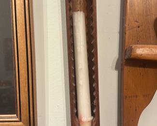 Carved Wood Candle mold — Long carved wooden canoe-style wall candle holder with scalloped interior channels designed to hold a taper candle. The piece is hand-carved with a warm medium-brown finish and shows light surface wear and small scuffs consistent with age and use; currently displayed with a white taper (not included). Suitable for rustic or nautical-themed decor, it mounts vertically as shown and measures roughly the size of a longwall accent. Solid, simple construction with a pleasing carved detail down the interior.
