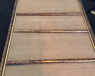 MCM Magnet & Grass Board — A framed magnetic memo board with textured woven fabric surface and five horizontal decorative metal slats for holding notes or photos. The frame has a mottled faux-burl finish with a narrow gold inner trim and a metal D-ring on the back for hanging. Shows light surface wear and a small fabric pull visible near the center; overall good usable condition for home or office. Measures compactly for a bedroom or desk wall and is ready to hang.