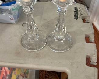 Clear Glass Candlestick Pair — Pair of clear pressed-glass candlesticks with faceted column stems and round bases, shown with standard taper candles. The glass is bright and transparent with minor candle wax residue visible on one holder; no obvious chips or cracks in photos. Solid, classic shape that fits traditional or contemporary tabletops and measures compactly for mantel or dining use.