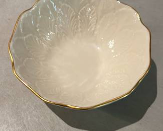 Lenox China Greenfield Sylvan Bowl — Lenox China Greenfield Sylvan small bowl with scalloped rim and embossed leaf motif, hand-decorated with 24K gold as labelled on the base. The creamy white porcelain has a delicate gold-trimmed edge and detailed relief work typical of Lenox's fine tableware. Maker's mark and original sticker are present on the underside; bowl appears structurally sound with only light surface wear consistent with gentle use. Compact decorative bowl ideal for candy, nuts or as an accent piece; see dimensions below.