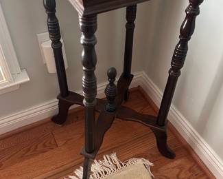 Marble Top Side Table — Elegant mahogany side table with a white and gray veined marble top, perfect for a living room corner or entryway. The table features turned legs, a cross-stretcher with finial detail, and a polished dark mahogany finish paired with a square marble slab. Table measures approximately 28 in tall with a 16 in square top and a slim 12 in depth at the base (see dimensions), and is light enough for easy repositioning while still feeling sturdy. In good condition with light surface wear to the wood and some age-related staining/discoloration on the marble top as shown.