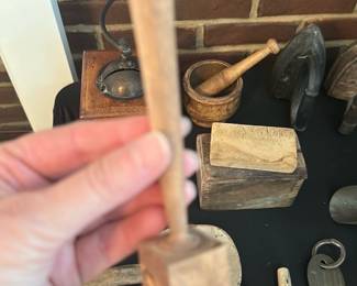 Wooden Mallet Hand Carved — Small hand-carved wooden mallet with a square head and turned handle, shown among other wooden kitchen and tool pieces. Solid, lightweight construction suggests use for small woodworking, leatherwork or kitchen tasks; no maker markings visible. Appears in used condition with surface wear, patina and small dents consistent with age and regular use. Compact size makes it useful for hobbyist benches or as a display primitive.