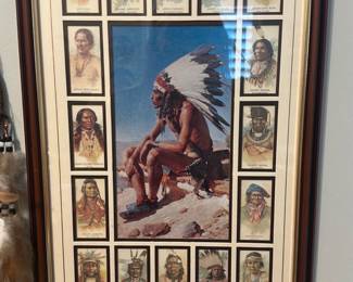 Framed Native American Portrait stamps — Large framed print featuring a central illustration of a seated Native American chief in full headdress surrounded by smaller portrait vignettes of various Native American figures. The piece is double-matted with a dark wood-tone frame and gilt inner trim; glass shows light reflections and no obvious cracks. Good decorative condition with normal age wear to mat edges and frame corners; suitable for wall display in an office or living room. Overall size and mat details below measured from photos and typical proportions; seller notes list location as Office Room.