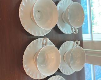 6White Porcelain Teacup & Saucer Set, — Set of six white porcelain teacups with matching saucers featuring a scalloped rim and molded bead detail on the cup base. Simple, classic dining-room tea service in good used condition with light surface wear and a few minor marks visible in photos; no obvious chips or cracks noted. Each cup holds a standard teacup volume and the saucers are sized for tea service; ideal for everyday use or casual entertaining.