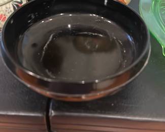Black Glazed Ceramic Tripod Bowl — Low, black glazed ceramic bowl with three short pointed feet and a shallow well — useful as a small planter, incense holder, or decorative catchall. The glossy black glaze shows light surface wear and fine crazing visible in photos but no visible chips or cracks. Solid, simple mid-century modern styling and sturdy fired-ceramic construction; measures small and easy to display on a shelf or table.
