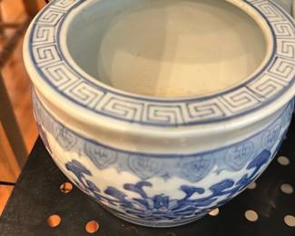 Made in China Blue & White Planter — Blue-and-white ceramic planter marked "MADE IN CHINA" on the base. Features a classic Greek-key rim band and floral scroll decoration around the body in underglaze blue. Solid, heavy pottery construction with surface wear and dirt on the base consistent with age and use; interior has some residue. Useful as a decorative planter or cachepot for a dining-room display.