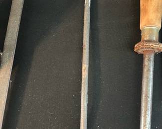 Iron Three-Prong Fireplace Fork — Heavy forged-iron three-prong fireplace fork with a long tapered shaft and an oval loop handle. Solid, utilitarian construction suggests 19th–early 20th century hearth tool use; the piece shows surface rust, patina, and light pitting consistent with age but appears structurally sound. Good for display with other vintage hearth tools or functional use in a wood-burning fireplace after cleaning. Measures long and slender; see dimensions for approximate size.
