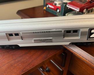 Southern Railway Silver Train Car — Silver-colored model train car marked 'SOUTHERN' and 'RAILWAY EXPRESS AGENCY 2550' with number 20 decal and 'Connor Henson' name. Constructed of molded metal/plastic with rolling trucks and detailed side ribbing, this piece appears to be a collectible model or toy railroad passenger/caboose coach used for display or model layouts. Approximately 16 inches long overall and lightweight, it's ideal for hobbyists adding period Southern Railway rolling stock to an HO/O scale layout (see dimensions). Good used condition with minor scuffs and one open/windowed panel visible; wheels and trucks appear intact.
