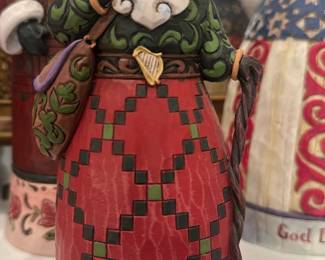 Jim Shore Irish Santa Figurine — Jim Shore Irish-themed Santa figurine from the Heartwood Creek line, decorated in carved-look paint with Celtic knotwork and a red tartan-style skirt. The base shows the Jim Shore mark and barcode; detailed hand-painted finish and a shepherd's staff add character. There is light surface crazing visible on the painted skirt consistent with the glaze/finish and normal display wear. Measures compactly for shelf or mantel display.