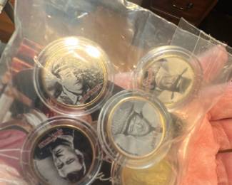 John wayne Commemorative Coin Lot — Lot of commemorative presidential coins in plastic capsules, sold together in the sealed bag shown. The set includes several bi-metal and silver-tone coins featuring US presidents (portrait images visible) with an informational certificate included. Coins appear unused and stored in protective capsules; the certificate text is partially visible but specific mint details or dates are not legible in the photos. Good collectible condition with minor handling wear to the outer bag only.