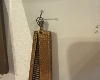 Brass Folding Travel Comb — Unmarked brass folding travel comb with a hammered surface and decorative border. The compact two-panel design opens to reveal narrow black teeth; hinge and bail show light surface wear and patina consistent with age. Solid-feeling and easy to carry in a pocket or bag, this piece is a functional vintage-style accessory with minor scuffs but no broken teeth visible. Measures small and lightweight—useful as a collectible or everyday travel comb.