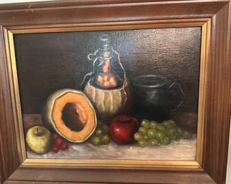 Still Life Oil Painting Framed — Framed still-life oil painting depicting melon, apples, grapes and pitchers on a dark background. The piece is in a carved wooden frame with gilt liner and appears to be an unsigned studio work; brushwork and varnish suggest oil on panel or canvas. Condition is good with minor surface varnish crazing and light scuffs to the frame consistent with age and display. Overall framed size is moderate and suitable for wall display in a living room or kitchen.