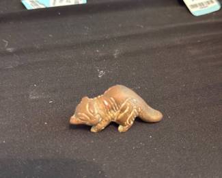 Brass miniature — Small solid brass miniature figurine as noted by the seller. The piece appears to depict a reclining or sleeping animal and is cast in a warm brass tone with surface patina and light handling wear consistent with age. Suitable as a small decorative accent, paperweight, or shelf display; no maker's marks or labels visible in the photos. Condition is good with expected surface oxidation and tiny surface scratches from use.