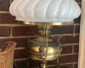 Brass Carousel Style Gone-With-Wind Lamp — Brass carousel-style gone-with-the-wind table lamp with a white swirled milk-glass shade and clear glass chimney. The lamp features a turned brass base and font with a pull-chain; wiring appears present but original and should be checked for safety before use. Shade has the distinctive spiral molded pattern and the brass gallery shows light surface wear and patina consistent with age. Stands medium-small on a tabletop and suits traditional or Victorian-inspired decor.