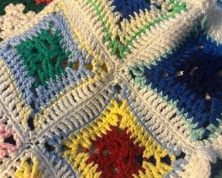 Handmade Crochet Granny Square Afghan — Handmade crochet granny-square afghan crafted from medium-weight acrylic yarn in multiple colors with a scalloped white border. The blanket shows a dense stitch and solid construction typical of home-knit throws and appears clean with no obvious stains or holes in the photos. Soft, cozy layer suitable for living room or bedroom use; lightweight but warm due to the doubled yarn in the border. Measurements are approximate — see dimensions for sizing.