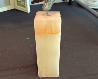Curtis Jere 1964 Sculpture — Curtis Jere metal sculpture dated 1964 mounted on a tall rectangular alabaster or onyx plinth, offered as shown. The piece displays the typical midcentury abstract form and verdigris patina on the metal element with a warm cream stone base that has surface age and minor staining near the top edge. Curtis Jere is known for decorative metal wall and tabletop sculptures from the 1950s–1970s; this small tabletop example is a collectible studio-era piece. Condition is fair to good with visible patina, light surface wear, and some discoloration on the stone base noted in the photos.