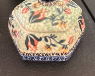 UNIKAT Hand Made in Poland Box — Decorative hexagonal covered trinket box marked UNIKAT and "HAND MADE IN POLAND" on the base. Hand-painted floral motif in green, coral and blue with a dark blue knob; interior also has a small floral decoration. Piece appears to be handcrafted Polish pottery (Bolesławiec style) with bright glaze and no obvious chips or cracks visible in photos. A compact, collectible decorative box suitable for jewelry or small keepsakes.