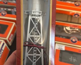 model power HO scale water tower — Model Power HO scale water tower in original display box with wiring for lighting and two figures noted on the box. The piece is molded plastic with ladder and elevated tank details; box shows light wear and a HOBBY LOBBY price sticker. Great for HO model railroad layouts as a scenic accessory; box-protected condition with minor shelf wear to packaging and the unit appears complete with attached wiring.