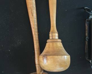 Wooden Turned Ladle — Pair of turned wooden ladles with long handles and deep bowls, shown as a matching set. Both appear hand-turned with visible tool marks and a warm patina from use; one ladle has a deeper rounded bowl while the other has a slightly flattened bulbous bowl and a small chip on the rim. Good usable condition for display or kitchen use with honest surface wear and age-related finish variation.