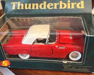 1955 Ford Thunderbird Model Car — This diecast 1955 Ford Thunderbird model car is presented in original retail box with clear display window. The red body with white hardtop and chrome-look details accurately represent the classic T-bird styling; box shows retail graphics reading "1955 Ford Thunderbird". Compact collectible ideal for display on a shelf or desk; box has some shelf wear and light scuffs on the plastic window but model appears intact. Sold as a collectible in fair to good condition for collectors or estate-sale shoppers.