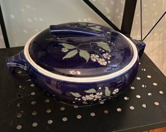 Hall's Floral Covered Casserole — Blue glazed covered casserole marked Hall on the base with Hall's Glidden Quality Kitchenware and pattern number 2685. Heavy ceramic serving piece with decorative pale green floral motif on deep cobalt ground and fitted lid with handle; interior is white glazed. Maker's marks on the underside read "HALL" and "HALL'S Glidden Quality Kitchenware Made in U.S.A."; shows light age wear and scuffing to base but no visible chips or cracks in the photos. Useful for serving or display in a dining room set.