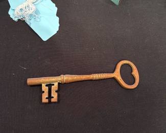 Vintage Skeleton Key — Heavy cast-metal skeleton key with a heart-shaped bow and a rectangular double-bit profile, shown here with surface rust and patina consistent with age. Likely a decorative or old warded key rather than a modern lock key; solid feel and substantial weight make it useful as decor or for restoration projects. Shows overall wear, surface corrosion, and verdigris in places but no obvious breaks. Measures roughly 7–8 inches long and would display well on a hook or as part of a vintage collection.