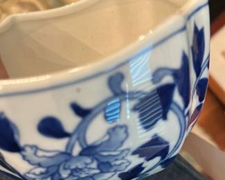 Blue White Floral Ceramic Planter — Blue-and-white ceramic planter with a scalloped hexagonal rim and hand-painted floral vine decoration. Sturdy glazed interior and exterior with visible crazing/age lines inside; no large chips or cracks seen in photos but shows light wear consistent with use. Good decorative piece for a dining room or tabletop plant; measures compactly and is easy to display.