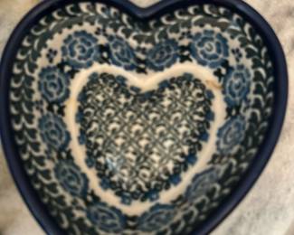 T. Liango Hand Painted Poland Bowl — Hand-painted heart-shaped ceramic bowl marked “T. LIANGO” and stamped "HAND PAINTED IN POLAND" on the base. Bold blue floral and lattice pattern inside with a deep blue rim; scalloped heart form suitable for serving or decorative use. Polish pottery like this is known for dense lead-free glazes and durable stoneware construction. Appears in good condition with no visible chips or cracks in the photos; light surface wear possible from normal use.