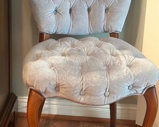 Tufted Grey Velvet Side Chair — Charming tufted side chair upholstered in soft grey velvet with button-tufted back and seat and shaped wooden cabriole legs. The chair combines a plush cushioned seat and supportive tufted back for comfortable occasional seating in a bedroom or living area. Estimated overall footprint is compact and ideal for a dressing area or as accent seating. In good condition with light surface wear to legs and minor fabric shading consistent with gentle use.