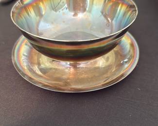Silver Plated Berry Bowl w/ Saucer — Silver plated two-piece berry or compote bowl with matching saucer showing iridescent toning from age and use. Markings visible on base read "P S" and what appears to be a number stamp; seller notes confirm silver plated. Good estate condition with surface scratches, light spotting, and areas of plating wear consistent with normal use; no major dents visible in photos. Useful as a serving piece or decorative accent; compact footprint makes it easy to display or store.