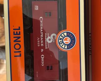 Lionel Chesapeake & Ohio Caboose — Lionel Chesapeake & Ohio caboose in original Lionel orange box with windowed lid. Photos show the maroon/red die-cast caboose with printed 'Chesapeake & Ohio' lettering and Lionel branded packaging; box label reads 'Chesapeake & Ohio Caboose' and model number 6-35582. Item appears unused in box with styrofoam inserts and illuminated interior noted on label; light shelf wear to box visible. Great for Lionel O gauge collectors or model train layouts.