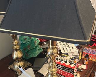 Brass Table Lamp with Black Shade — Classic turned brass table lamp with decorative finial and a black fabric shade trimmed in gold. The lamp shows a substantial stepped square base and baluster-style column with polished brass finish; shade has light dust and minor wear consistent with normal use. Works as a traditional desk or bedside lamp and pairs well with classic or transitional decor. Sold as pictured; one lamp with shade and finial included.