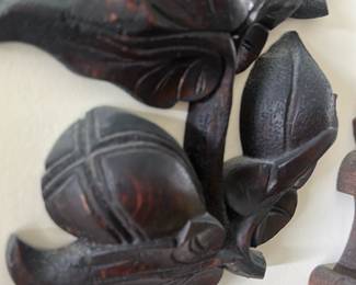 Carved Wood Floral Wall Sconce — Decorative carved wood floral wall sconce with stylized leaves, buds and berry clusters; photographed in the sun room. The piece is carved from dark-stained hardwood with visible hand-tooling and a warm reddish-brown undertone. Overall size is modest and suitable for small wall groupings or as an accent near mirrors or entryways. Condition is good with minor surface wear and light scuffs consistent with age and use.