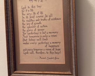 Framed Sanskrit Poem Print — Small framed wall print featuring a decorative Sanskrit heading and an English poem titled "Look to this day" (attributed on the print to an "Ancient Sanskrit Poem"). The frame is a molded wood-look frame with a double mat in neutral tones; piece appears made for home decor and is suitable for hanging in a bedroom or hallway. Good overall condition with light surface wear to the frame visible in photos and no apparent damage to the print or glass. Measures approximately 11 x 8 inches (frame outer dimensions approximate) and is ready to hang.