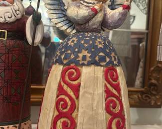Heartwood Creek 'God Bless America' Ange — Hand-painted Heartwood Creek angel figurine with patriotic red, white and blue dress and American flag; base reads "God Bless America." The underside stamp shows Heartwood Creek and a printed sticker with item code 11704; piece is likely resin/wood-look and designed for shelf display. Good overall condition with normal surface wear consistent with display; no visible chips or cracks in photos. Stands approximately 10 in tall and is a decorative accent for living rooms, sun rooms or patriotic displays.