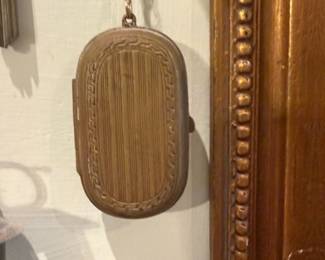 Brass Oval Vesta Case — Small brass oval vesta or match safe with vertical engraved banding and a decorative border on both faces. The hinged case shows surface wear and patina consistent with age but no obvious dents; clasp appears intact from photos. Lightweight, pocket-sized accessory likely late 19th–early 20th century style, suitable for collectors of small brass or Victorian-era pocket items. Measures approximately 2.5 inches tall and 1.5 inches wide so it's easy to display or carry.
